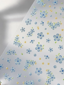 Close-up of five-petal flower nail stickers with embossed texture and blue floral patterns