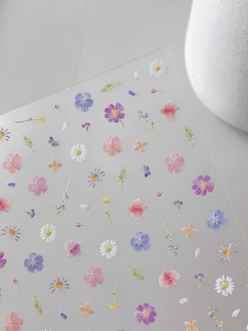Detail shot of 3D embossed floral nail stickers featuring colorful daisy patterns