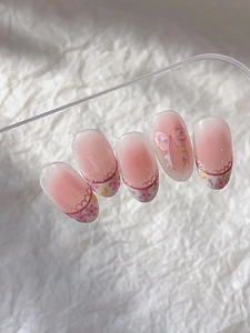 Close-up of pink blush gradient press-on nails with floral and bow designs