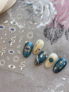 Macro view of bohemian gold foil nail stickers with evil eye and star patterns