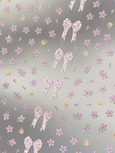 Detailed macro of relief bow and floral patterns on translucent nail art stickers