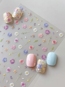 Detail of 3D embossed floral nail stickers featuring daisy and orchid patterns