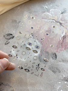 Macro detail of YT4718 nail art stickers with gold foil eyes and celestial motifs
