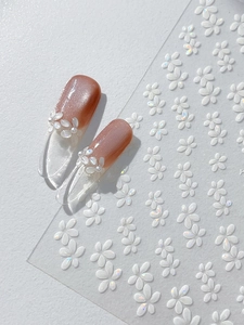 Makroaufnahme von 3D-Muschelblumen-Nagelstickern mit dezentem, schillerndem Effekt