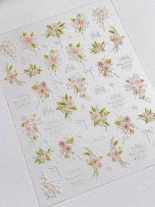 Detailed close-up of 5D embossed nail stickers featuring pink floral and white bow patterns