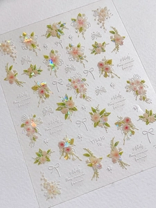 Close-up of 3D embossed floral nail stickers with pink flowers and aurora bow designs