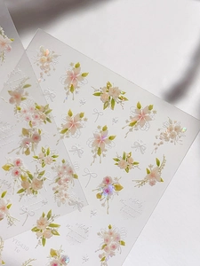 Macro shot of 3D embossed nail stickers featuring pink roses and white floral bows