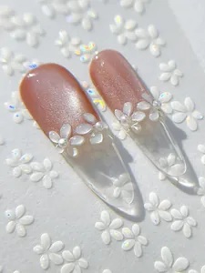 Makroaufnahme von YT5478 Mandelnägeln mit 3D-Blüten und Perlen in hellem Nude-Verlauf