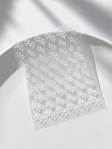 Nahaufnahme von 3D-geprägten Nagelaufklebern mit Muschelglanz und Blumenmuster
