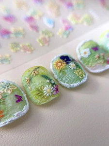 Macro detail of 3D embossed floral nail stickers featuring Monet garden oil painting style