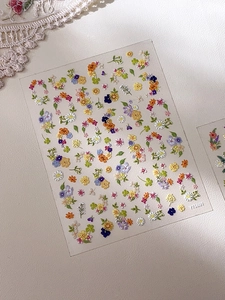 Macro detail of 5D embossed floral nail stickers with colorful rose and daisy textures