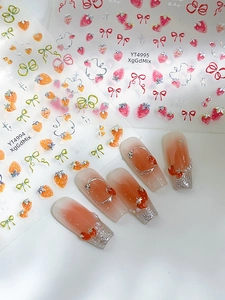Dettaglio di adesivi per unghie con fragole e fiocchi su manicure sfumata francese