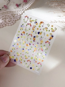 Close-up of Monet Garden floral nail stickers featuring colorful daisies and flower patterns