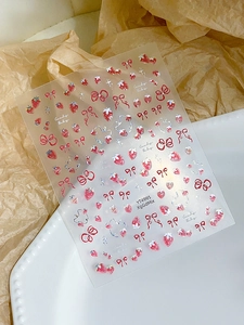 Dettaglio di adesivi per nail art con fragole e fiocchi su vassoio in ceramica