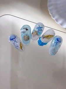 Vue détaillée du nail art 3D gaufré sur le thème marin avec méduses et détails de coquillages