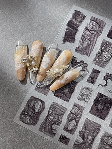 Detailed macro view of black lace nail stickers with 3D pearl and rhinestone decorations