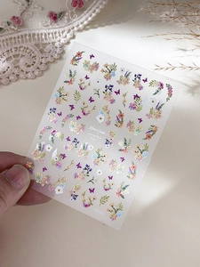 Detail of floral nail art stickers with butterfly patterns on a transparent film