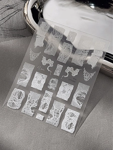 Macro detail of white lace nail art stickers with fine mesh patterns and elegant lines