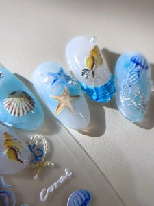 Vue macro d'autocollants 3D pour ongles avec motifs de méduse, étoile de mer et corail