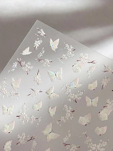 Detailed macro view of 5D embossed butterfly and cherry blossom nail art stickers