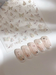 Detail of white butterfly and cherry blossom nail stickers with pearl finish and rhinestones