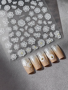 Detail of YT4032 3D embossed white floral nail stickers applied on manicured nails