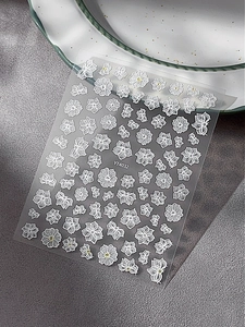 Macro detail of white embossed flower and butterfly nail art stickers on YT4032 sheet