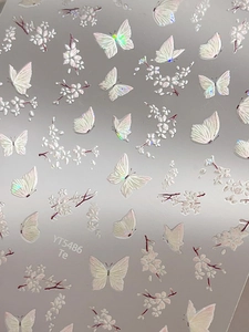 Macro shot of 5D embossed white butterfly and cherry blossom nail stickers with laser effect