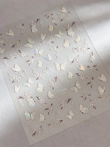Detailed macro view of 5D white butterfly and floral embossed holographic nail art stickers