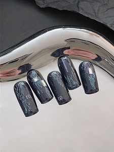 Macro view of cyberpunk press-on nails with black circuit board patterns and rhinestones