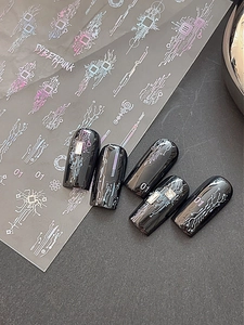 Macro shot of cyberpunk nail stickers with metallic circuit lines and atomic symbols