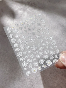 Detailed view of YT4032 white embossed nail stickers with flower and butterfly patterns