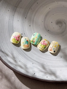Detailed view of handmade cactus and floral nail art on a ceramic display tray