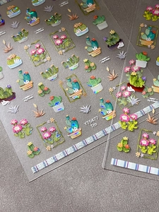 Holographic cactus and succulent nail stickers with rainbow laser finish on sandy background