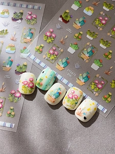 Detail of colorful cactus nail stickers showing hand-painted patterns on almond nails