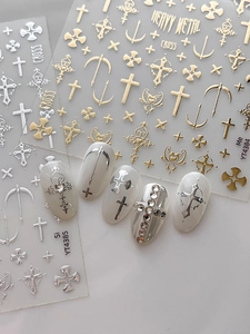 Detail of heavy metal style gold and silver cross nail stickers with gothic art designs