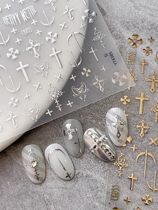 Detailed view of 3D gothic cross nail art stickers in metallic gold and silver finishes
