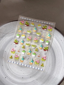 Detail showing cactus and succulent nail stickers with gold accents on a ceramic tray