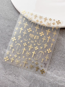 Detail of gold gothic cross nail stickers YT4384 on a grey stone texture background