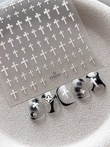 Silver metallic cross nail stickers with star accents on black and white manicure