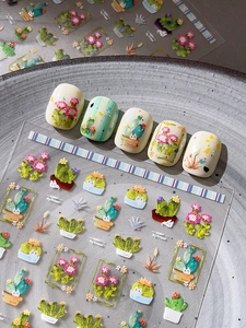 Macro view of cactus and floral nail stickers on a textured grey decorative plate