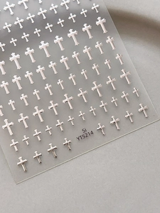 Macro view of 3D silver cross nail art stickers on transparent backing film