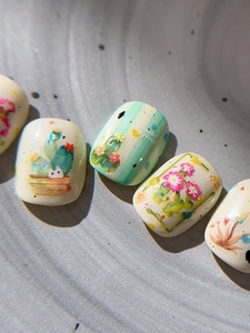 Detailed macro view of cactus nail art stickers with 3D floral and cute cat patterns