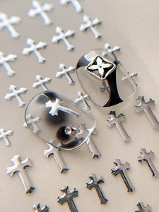 Macro view of silver cross nail art stickers with metallic finish and gothic style