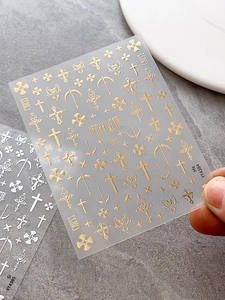 Detail of gold and silver gothic cross nail stickers with metallic embossed finish