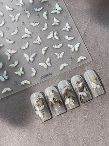 Detailed macro view of laser silver butterfly nail stickers with pearly 3D manicure effect