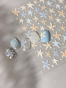 Detail of starfish nail art stickers with embossed sea patterns and pearl embellishments