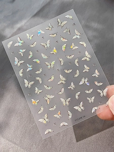 Detailed view of silver laser butterfly nail art stickers with iridescent metallic finish
