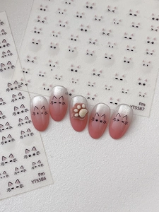 Detailed view of cute cat expression nail stickers and 3D cat paw art design