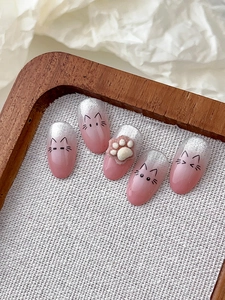 Detail of pink gradient cat press-on nails with silver glitter and 3D plush paw charm
